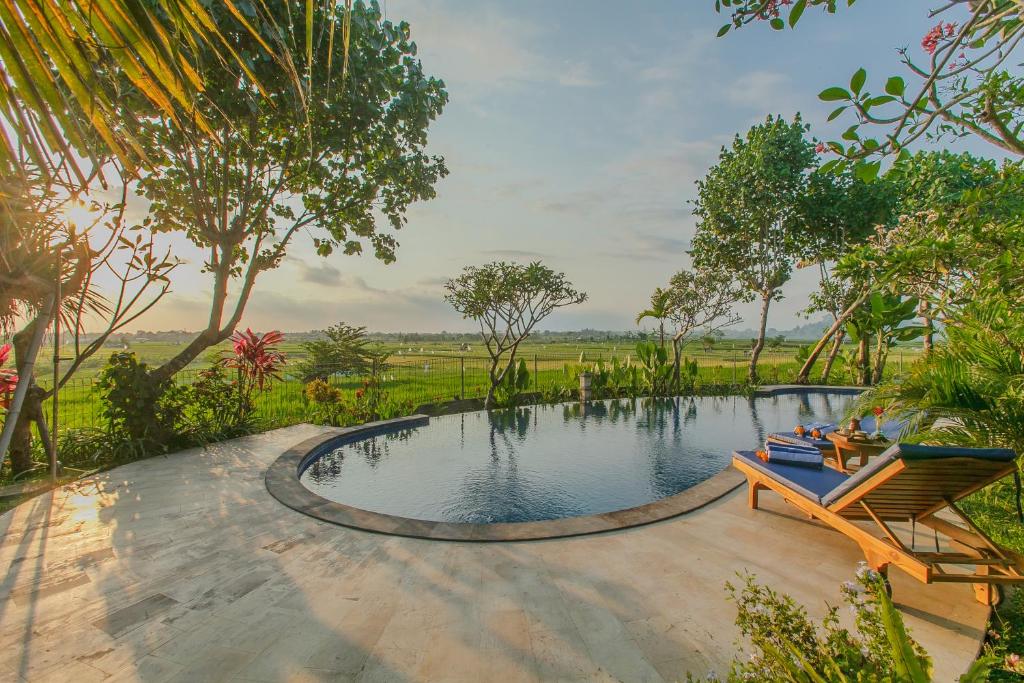 a swimming pool in the middle of a garden at Villa D'Carik Bali in Denpasar