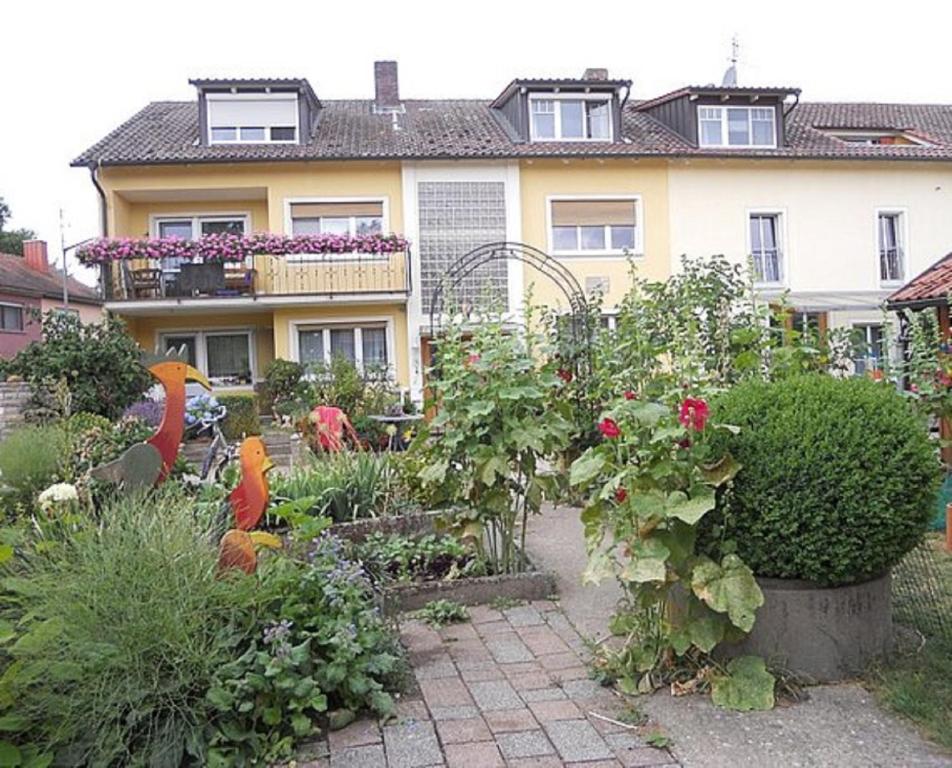un jardin avec des fleurs en face d'une maison dans l'établissement Ferienbauernhof Storchenhäusle, à Simmershofen