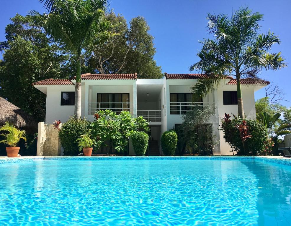 a villa with a swimming pool in front of a house at Coral Blanco Hotel in Sosúa