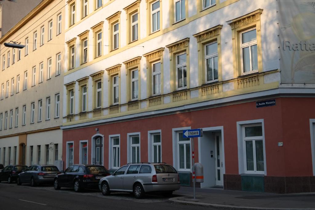 a building with cars parked on the side of a street at Pension am Wienfluss in Vienna