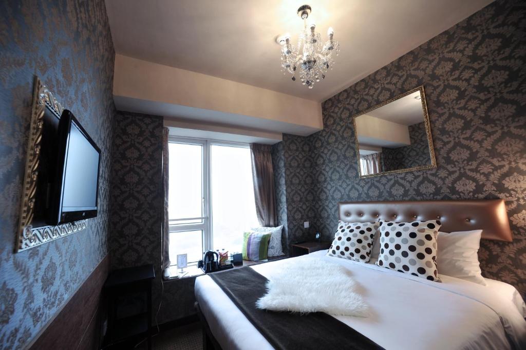 Postel nebo postele na pokoji v ubytování Ramada Grand Tsim Sha Tsui