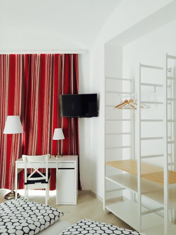 a white room with a desk and a tv at Pension am Wienfluss in Vienna