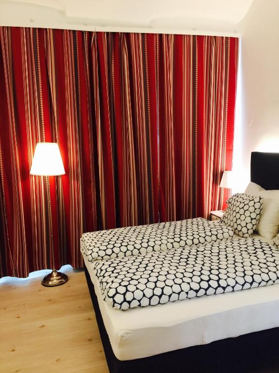 a bedroom with a bed and a red curtain at Pension am Wienfluss in Vienna