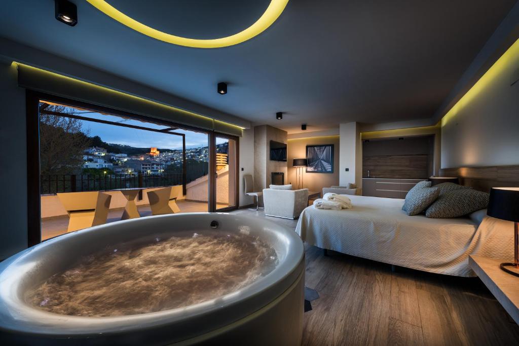 a bedroom with a tub in the middle of a bed at Suites Finca Los Olivos in Alcalá del Júcar
