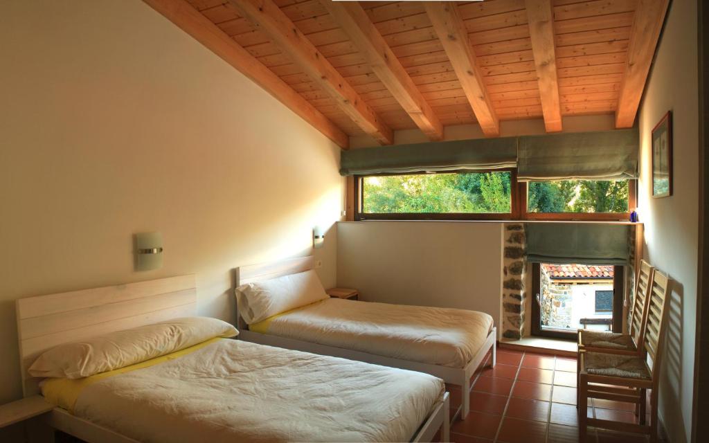 um quarto com 2 camas e uma janela em Hotel Rural Las Encinas em Santa María de Redondo