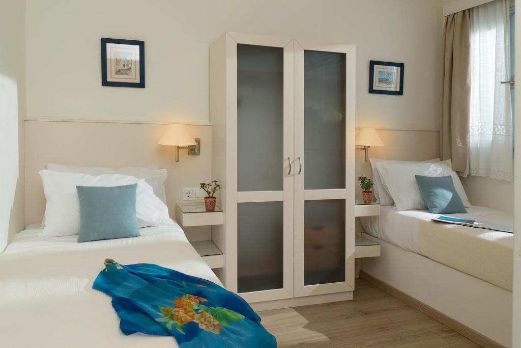 a hotel room with two beds and a cabinet at Perigiali in Skiros