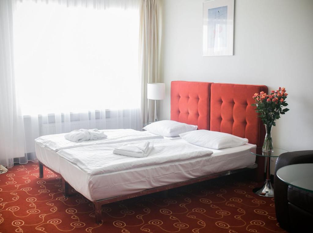 a bedroom with a large bed with a red headboard at Hotel Dona in Kaliningrad