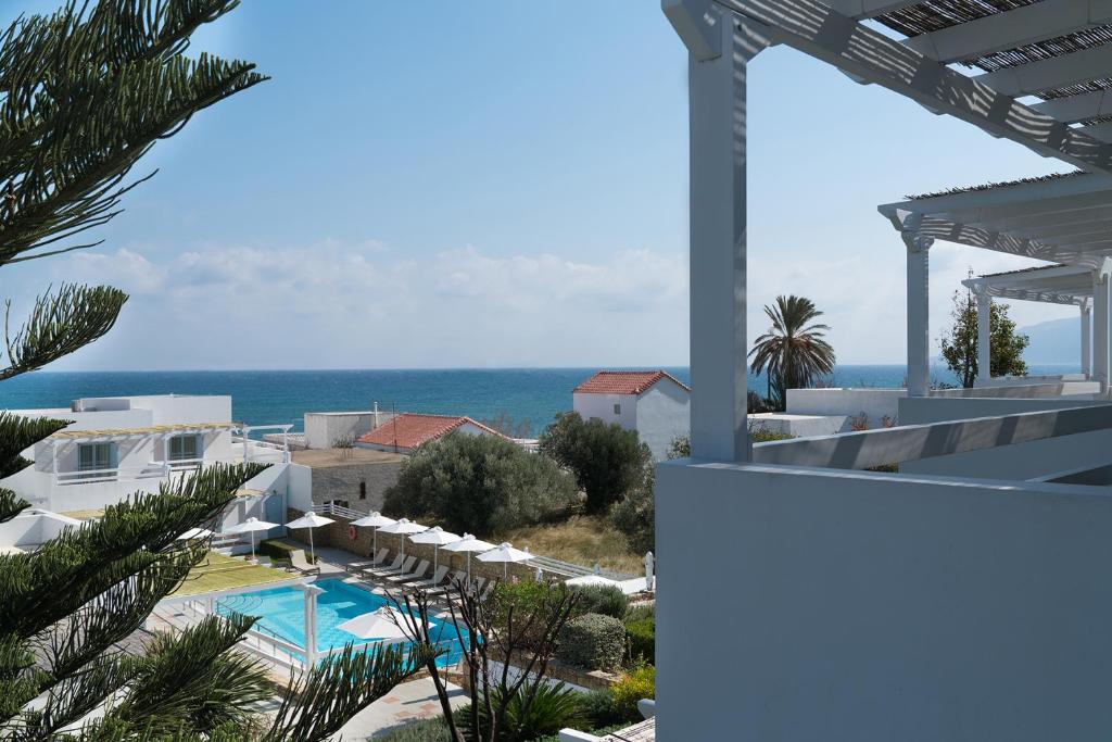 a view of a resort with a swimming pool and the ocean at Perigiali in Skiros
