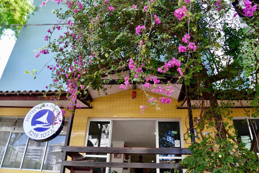 a building with a tree with pink flowers at Hotel Casa De Praia in Fortaleza