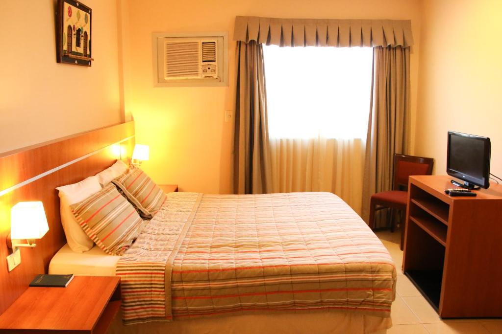 Ένα ή περισσότερα κρεβάτια σε δωμάτιο στο Olimpo Hotel & Suites