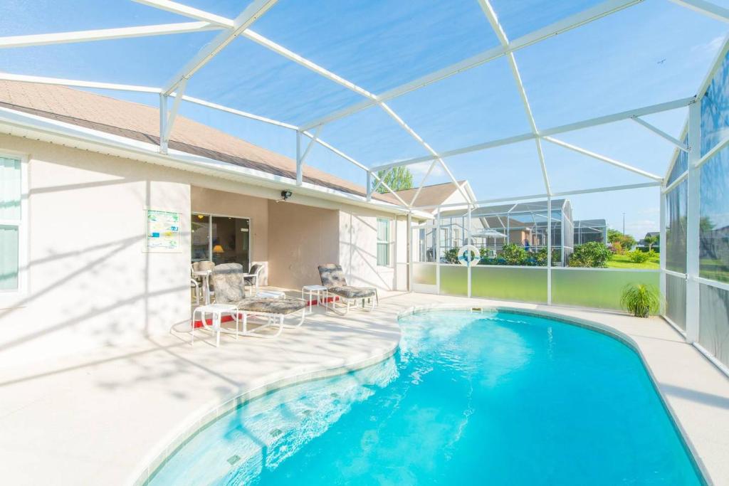 una piscina in una casa con soffitto in vetro di Orlando Mouse Manor a Davenport