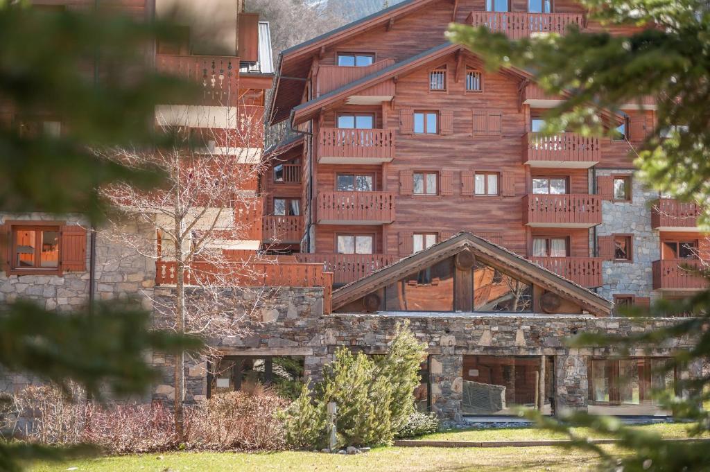 a large wooden building with balconies on it at Residence Les Fermes du Soleil - maeva Home in Les Carroz d'Araches