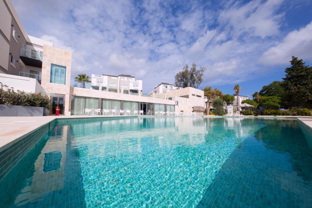 - une piscine d'eau bleue en face d'un bâtiment dans l'établissement Urban Valley Resort & Spa, à San Ġwann
