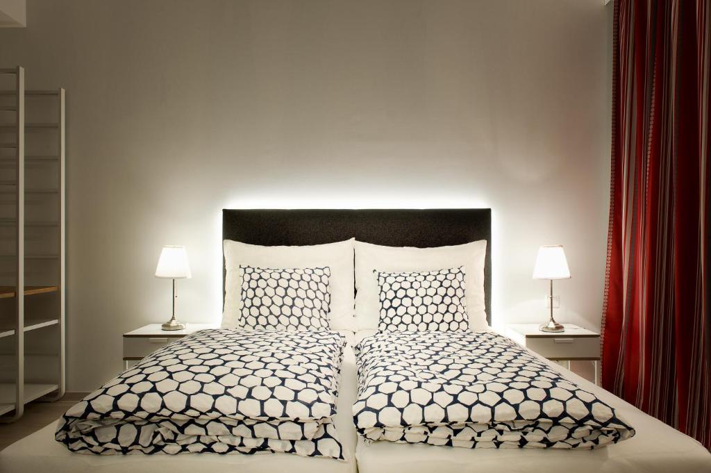 a bedroom with a large bed with two lamps at Pension am Wienfluss in Vienna