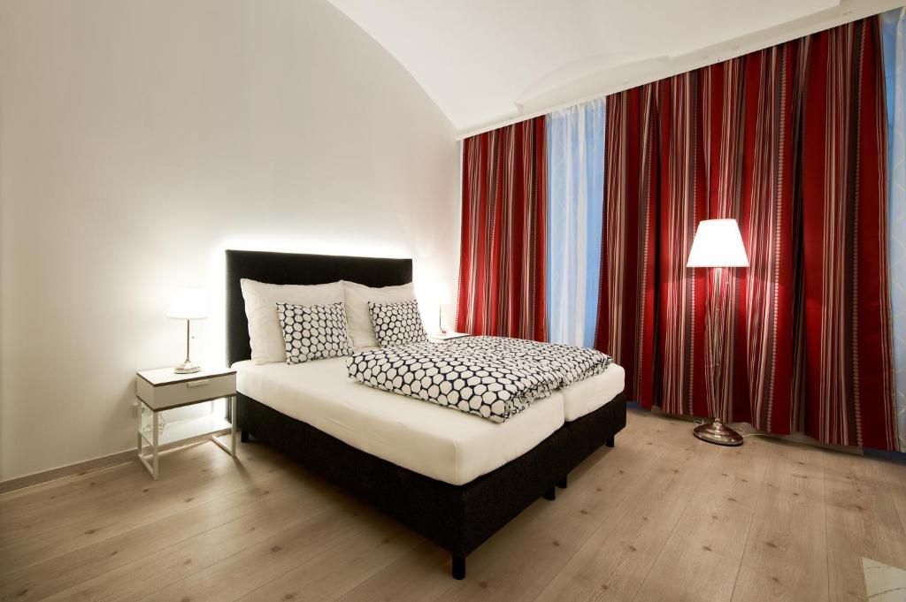 a bedroom with a bed and red curtains at Pension am Wienfluss in Vienna