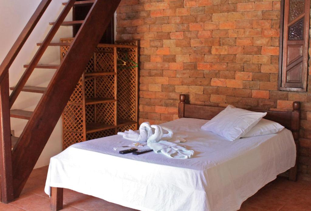 uma cama num quarto com uma parede de tijolos em Pousada do Pepe em Morro de São Paulo