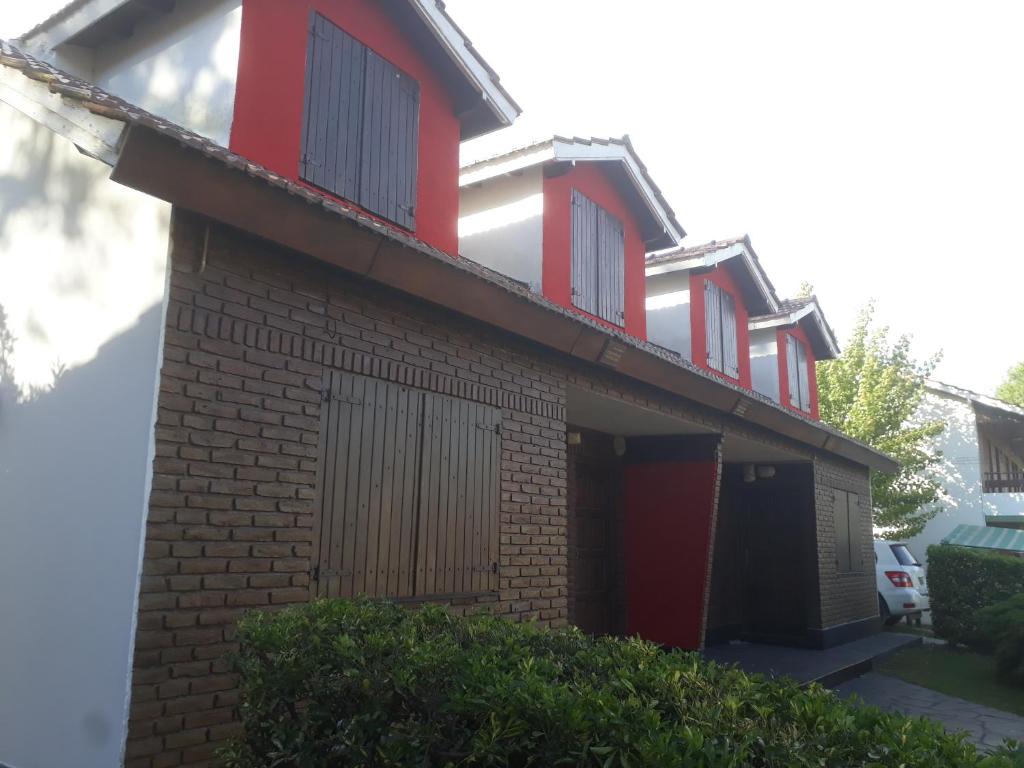 ein Haus mit roten Akzenten darauf in der Unterkunft Los Cuatro Corazones in Villa Gesell