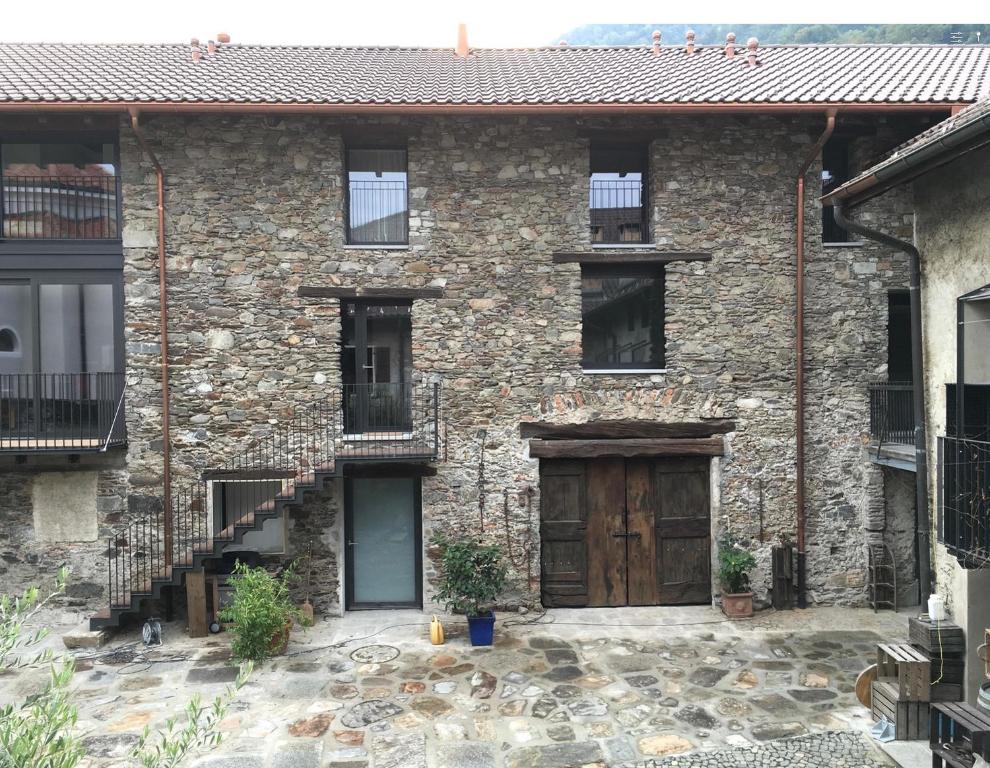 una antigua casa de piedra con puerta de madera en Antica Sosta dei Viandanti, en Cadenazzo