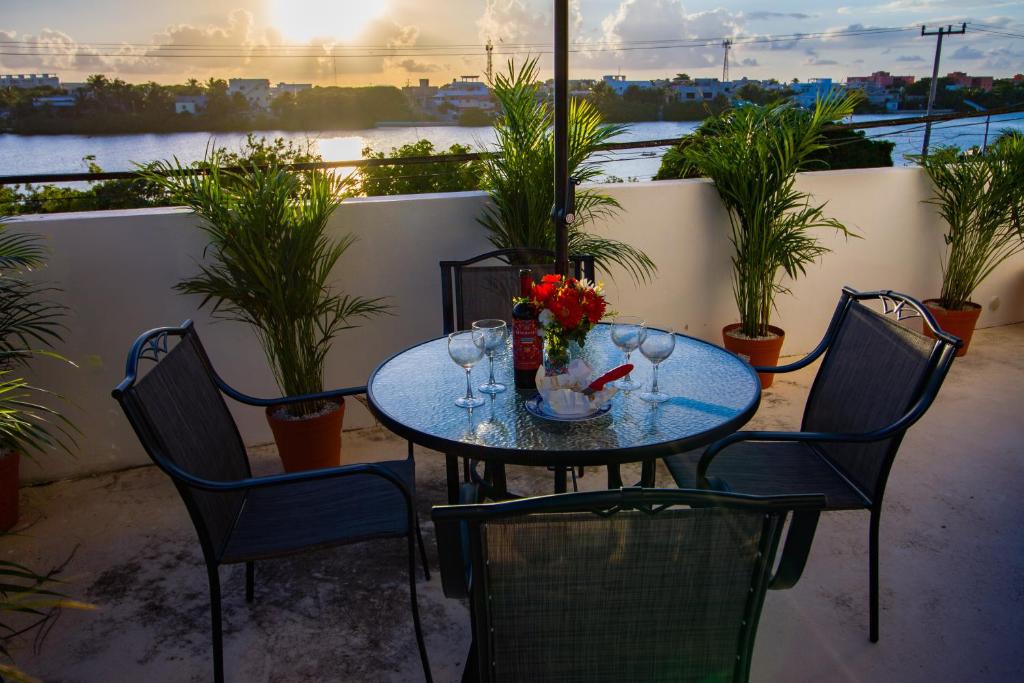een tafel met wijnglazen en bloemen op een balkon bij Suite Isla Mujeres in Isla Mujeres