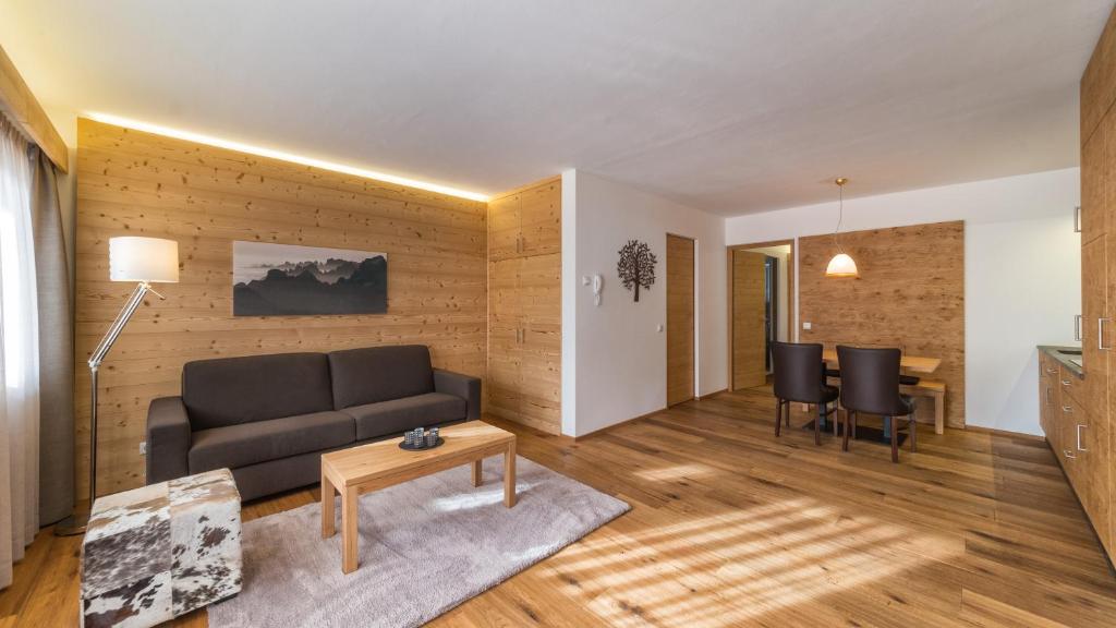 - un salon avec un canapé et une table dans l'établissement ALMA mountain residence, à Dobbiaco