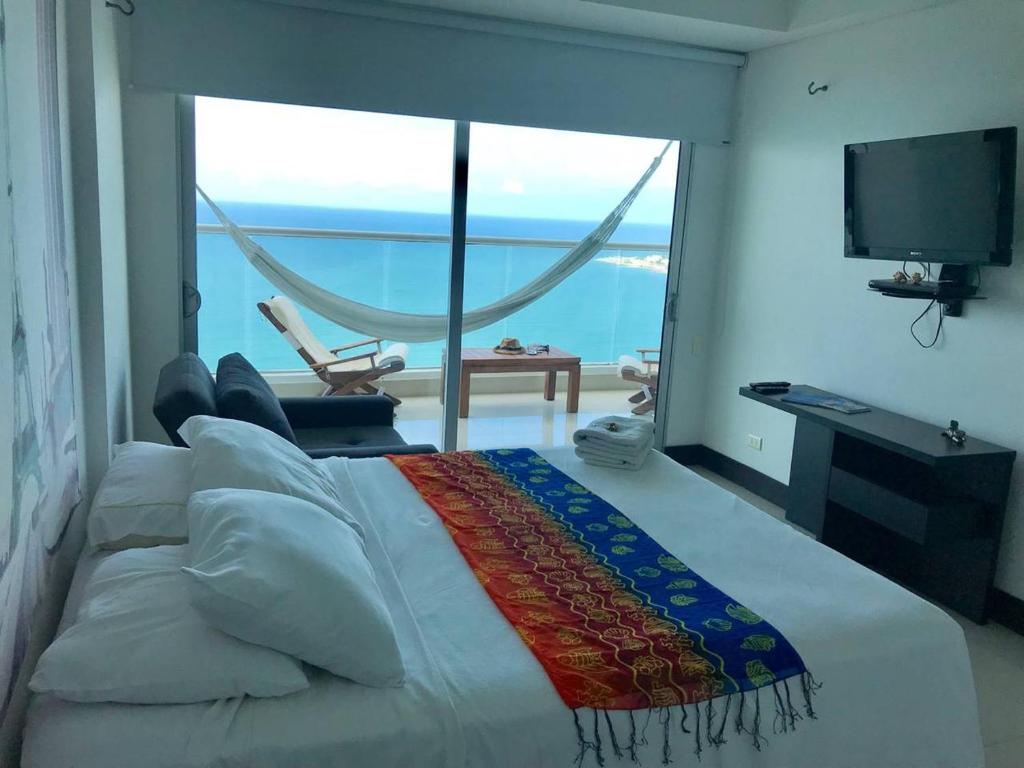 a bedroom with a bed with a view of the ocean at Palmetto Eliptic 4003 in Cartagena de Indias