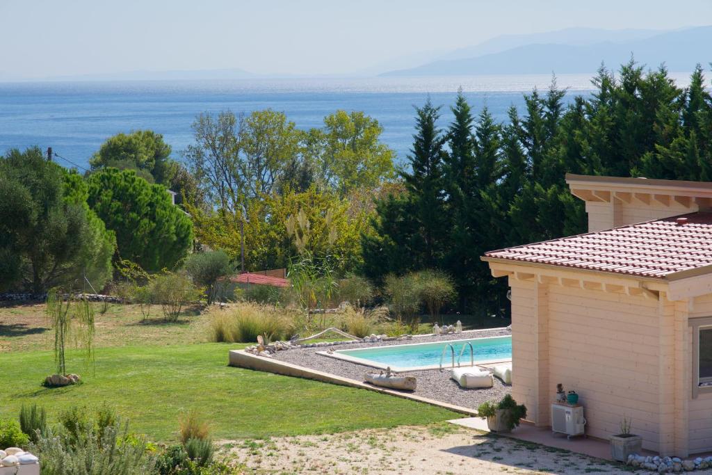 une arrière-cour avec une piscine et l'océan dans l'établissement Driftwood Villa, à Karavádhos