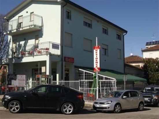 twee auto's geparkeerd voor een gebouw bij Residence Mariele in Tavazzano
