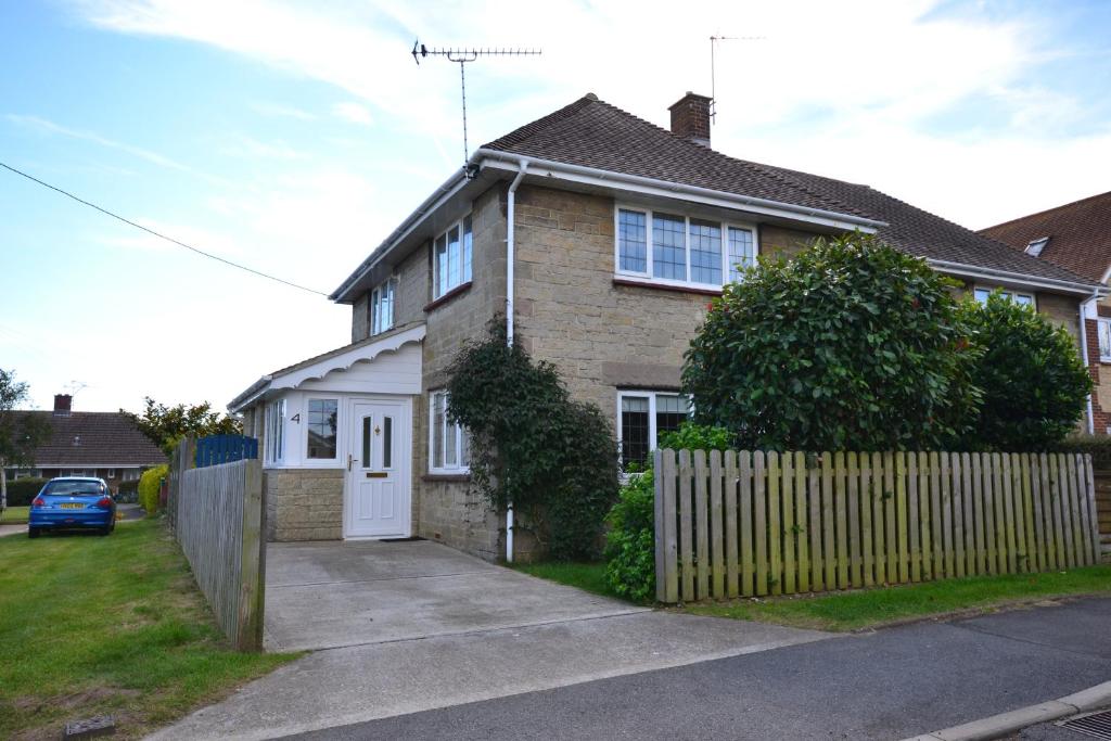 una casa con una puerta blanca y una valla en 4 Brooks Close, en Bembridge