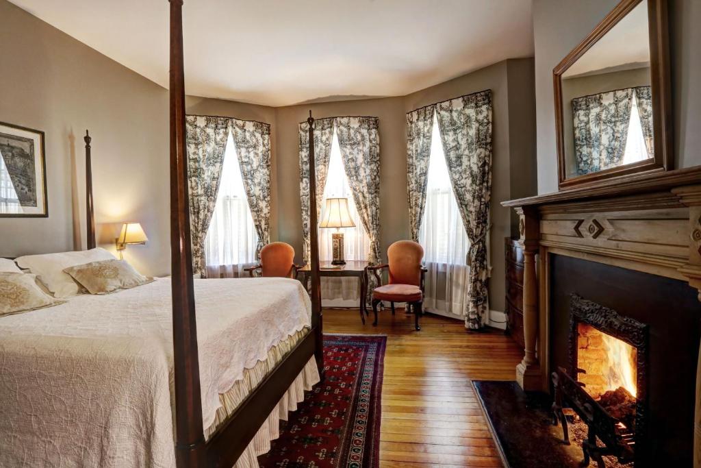 a bedroom with a bed and a fireplace at 200 South Street Inn in Charlottesville