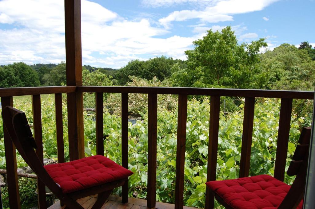 une terrasse couverte avec une chaise et une vue sur un champ dans l'établissement Casa de las Flores Sober Ribeira Sacra, à Sober