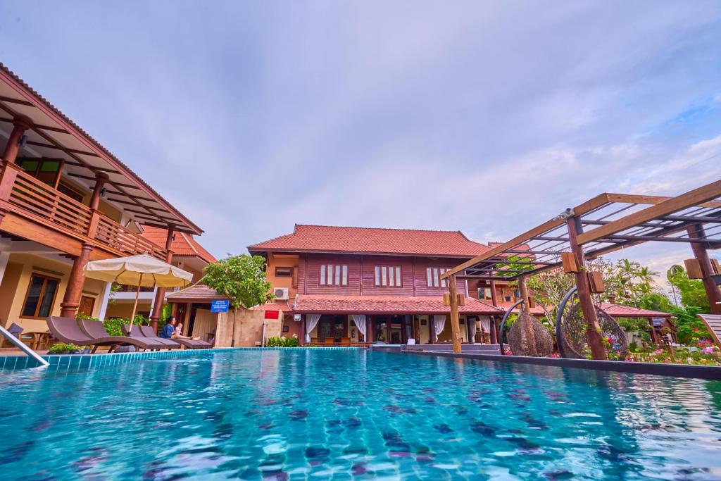 a large swimming pool in front of a building at Mina Garden Villa Resort in Chiang Mai