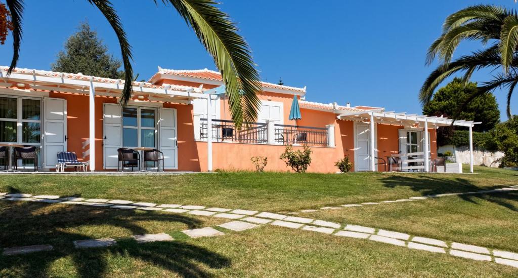 a house with a palm tree in front of it at Arion Hotel in Kokkari