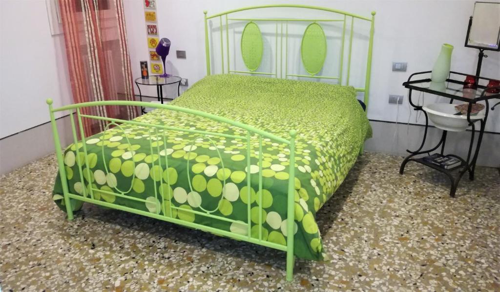 een groen bed in een kamer met een wastafel bij A CASA DI PEPLIS in Venetië