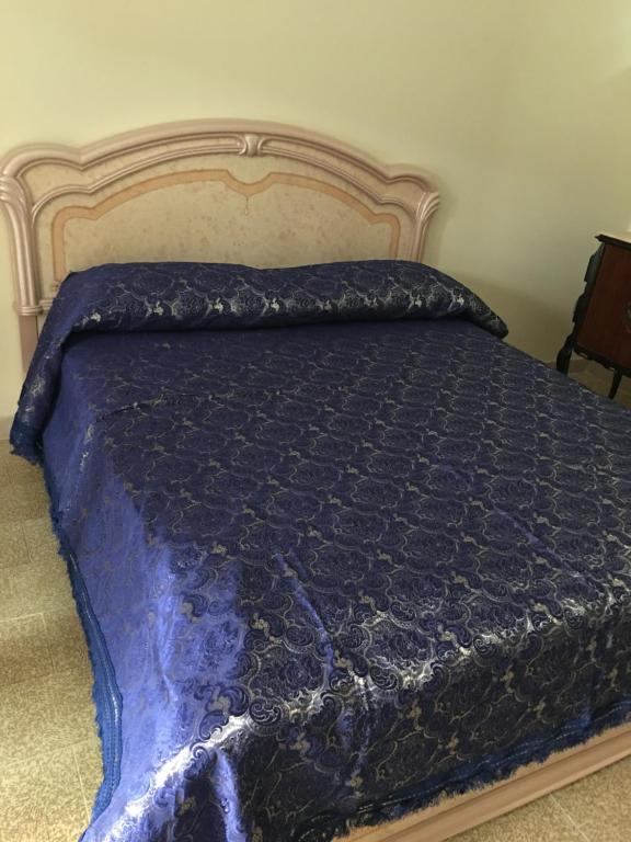a bed with a blue comforter on top of it at La tua casa vicino Matera in Grassano