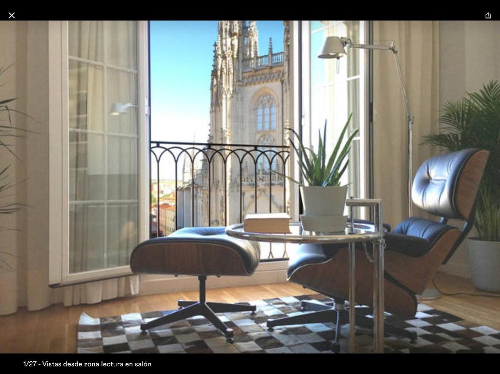 ブルゴスにあるContemplando la Catedral by Exclusive Burgos Apartmentsのテーブルと椅子、窓が備わる客室です。