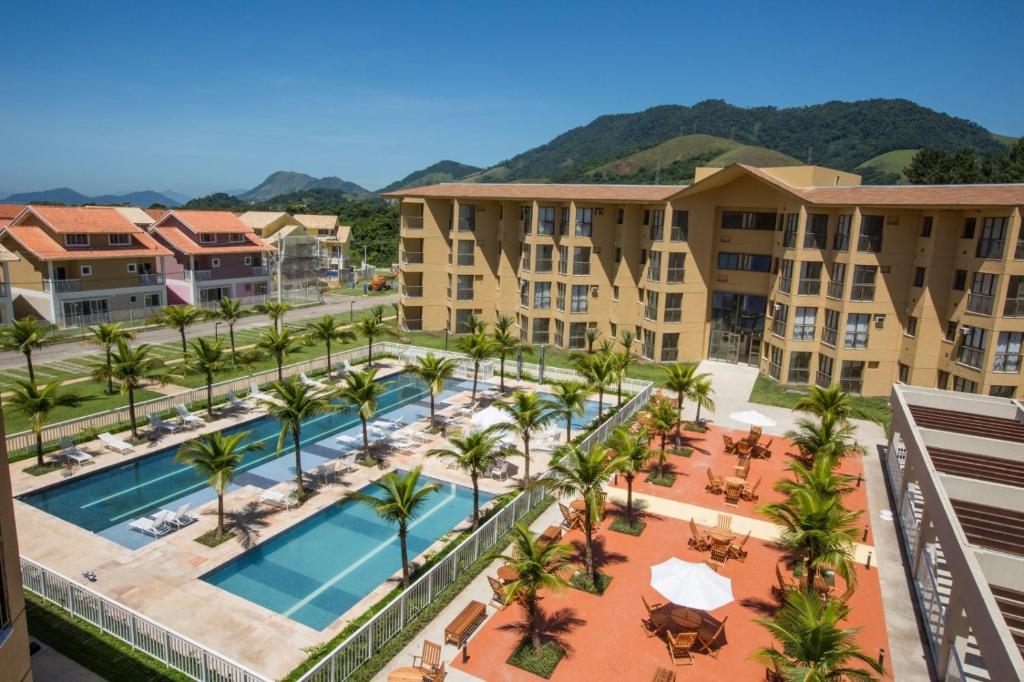 an aerial view of a resort with a pool and palm trees at Loft Reserva do Sahy - Mangaratiba in Mangaratiba