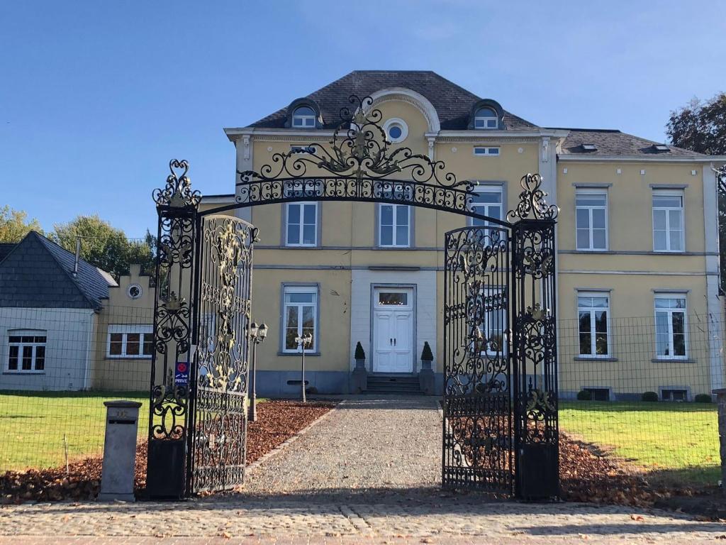 un cancello decorato di fronte a una grande casa di Kasteel B&B Sint-Bartel a Geraardsbergen