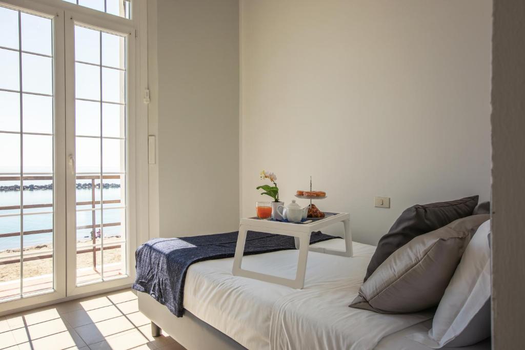 a bedroom with a bed and a table with a view at Casa F.A.C.I in Marina di Massa