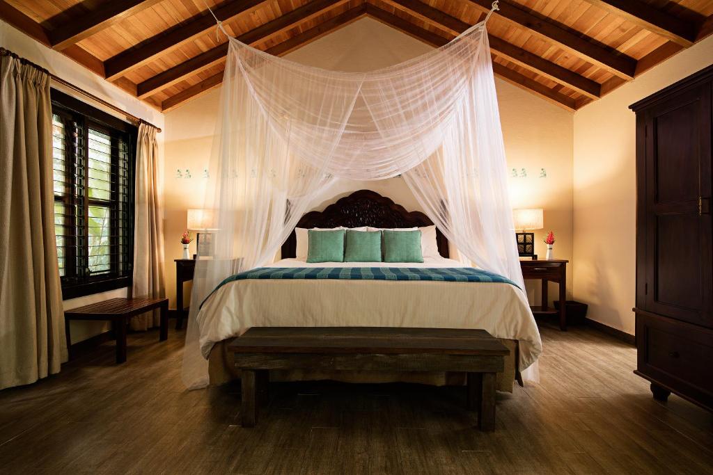 a bedroom with a bed with a canopy at Hotel Jungle Lodge Tikal in Tikal