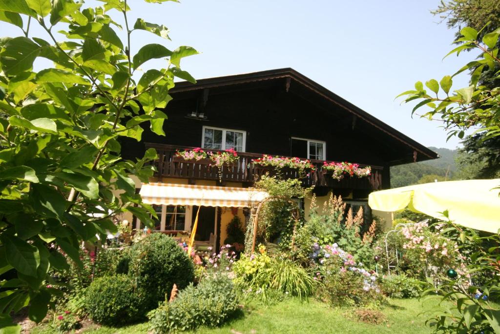 ein Haus mit einem Balkon mit Blumen darauf in der Unterkunft Appartement am Schilift in Sankt Gilgen
