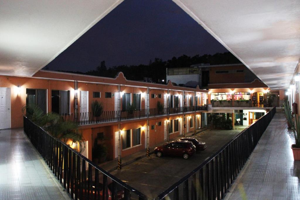 a building with a car parked in a parking lot at night at Hotel Villa Las Rosas in Tepic