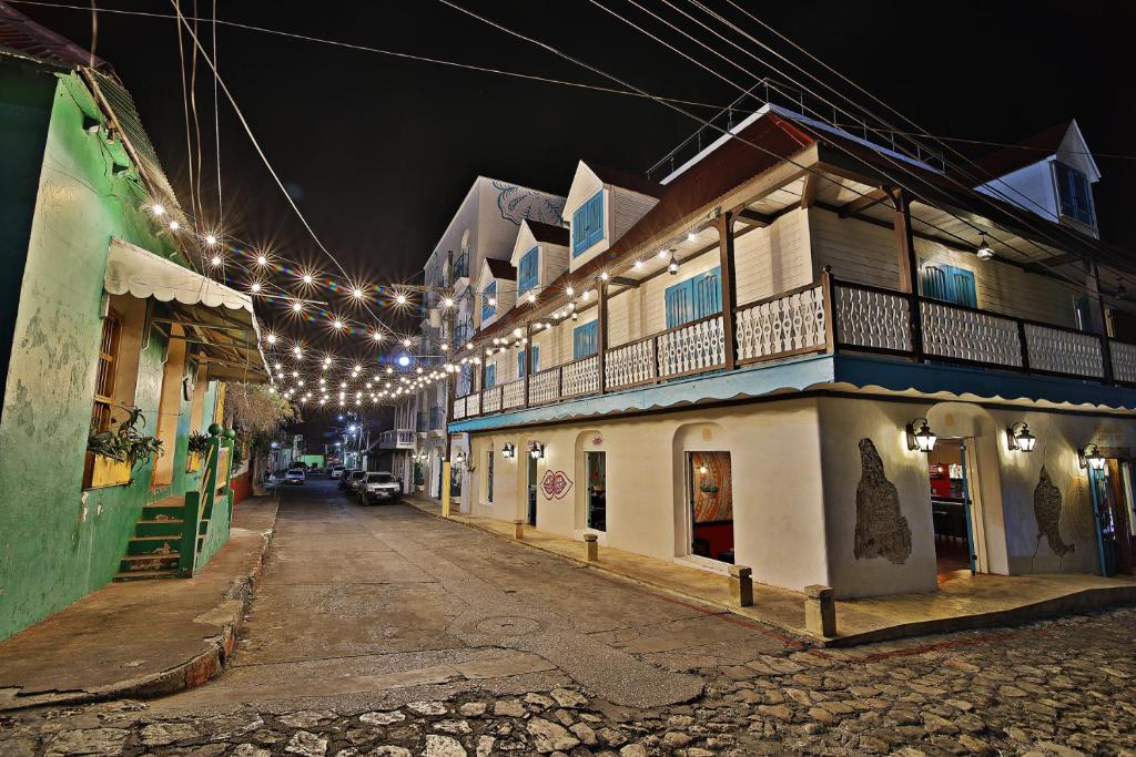 une rue la nuit avec une chaîne de lumières dans l'établissement Hotel Isla de Flores, à Flores