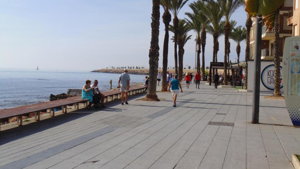 トレビエハにあるApartamento Moriones A. A150 m del mar en centro de ciudadの海辺遊歩道を歩く人々