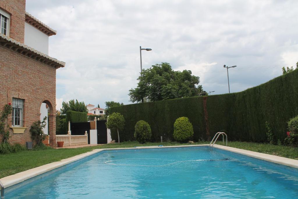 a swimming pool in a yard next to a house at Villa Marín in Suspiro del Moro