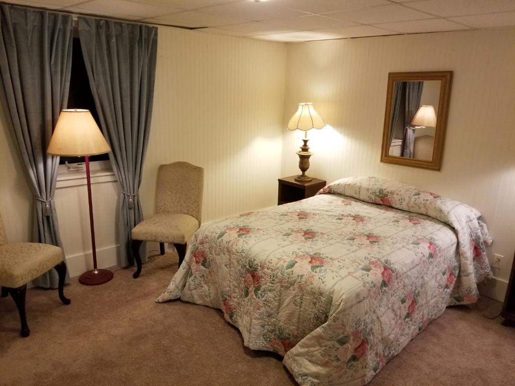 una camera con letto, lampada e sedia di Southern Hospitality House a Lakewood