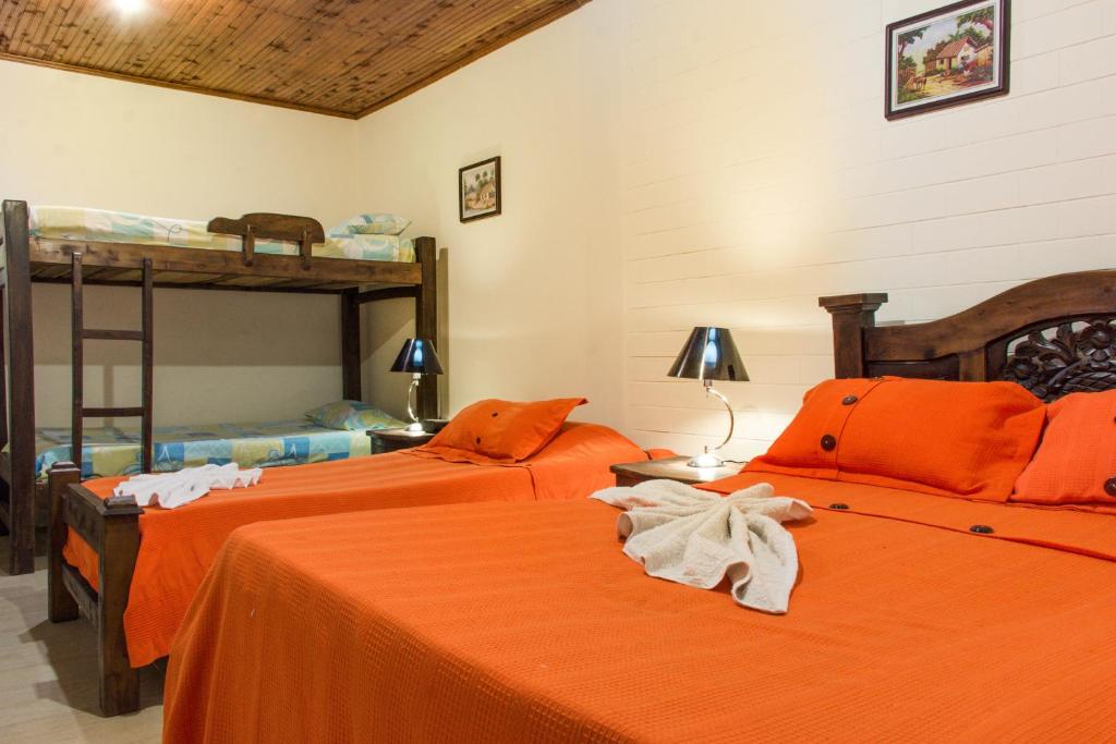 卡利的住宿－Hotel D' Oscar，一间卧室配有两张床和一张双层床。