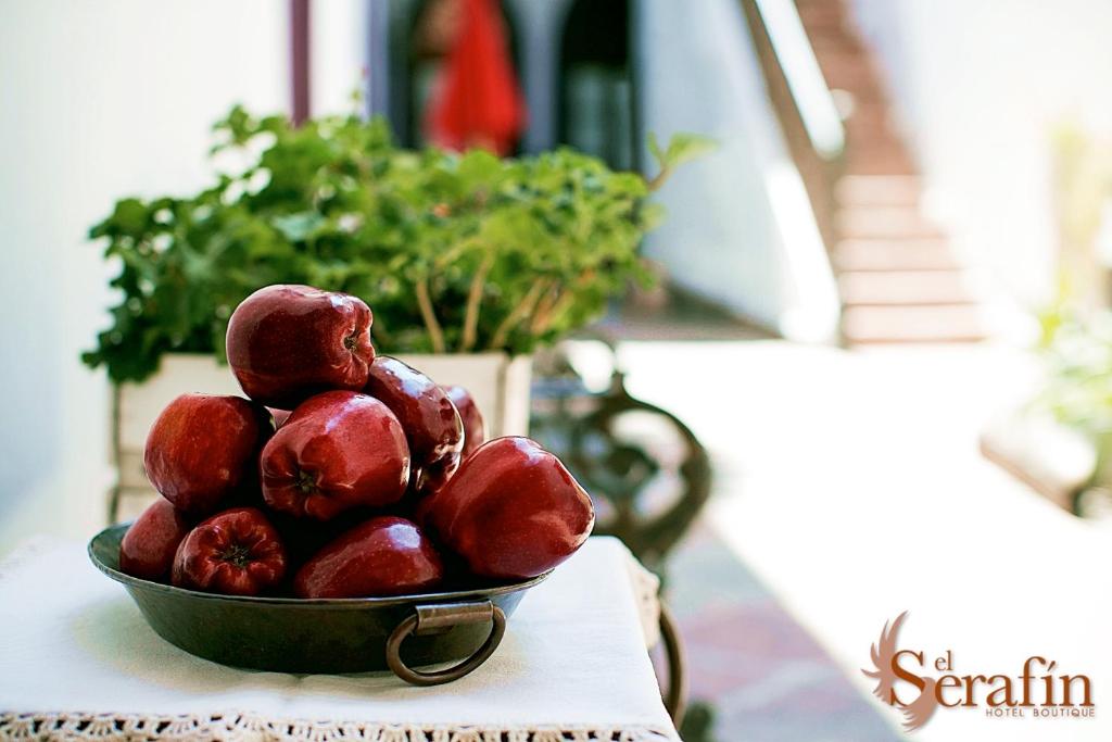 El Serafin Hotel Boutique في كيريتارو: وعاء من الفواكه الحمراء على طاولة