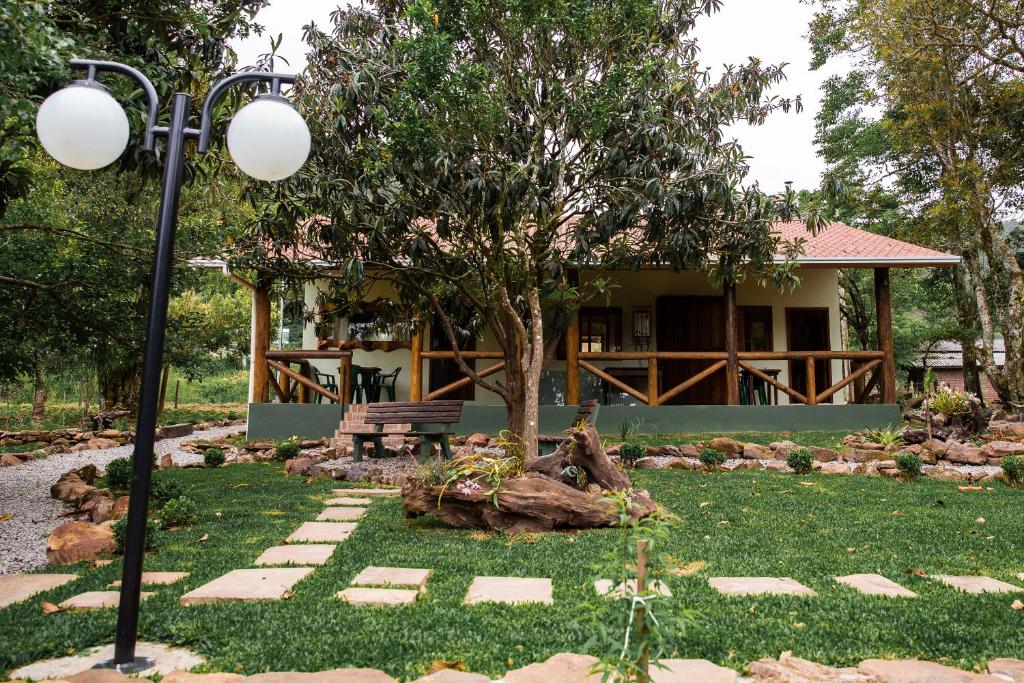 a house with a tree and a street light at Ninho das Águias Cabana in Nova Petrópolis