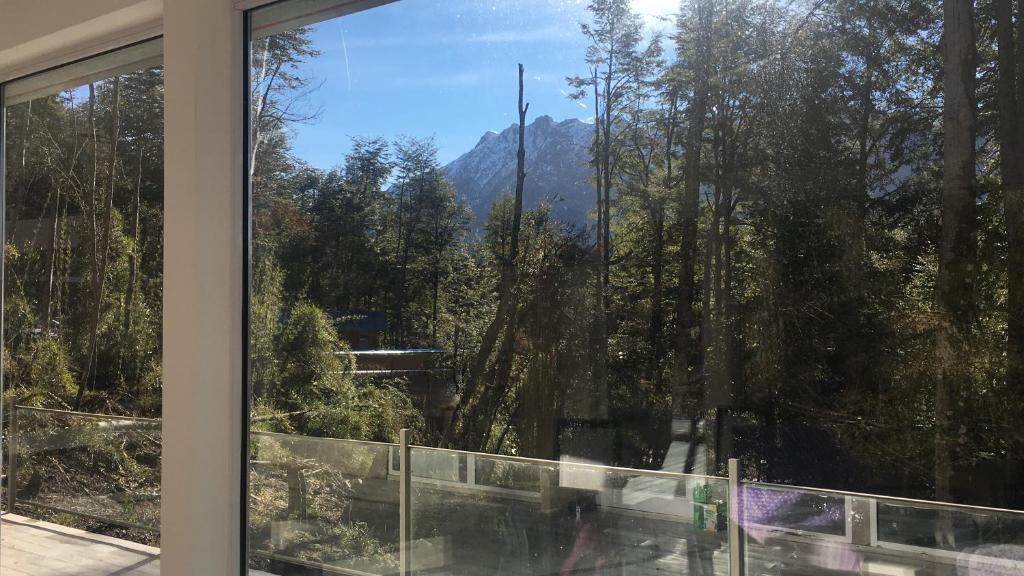 a window with a view of a mountain at Casa moderna en el bosque y montaña in Villa La Angostura