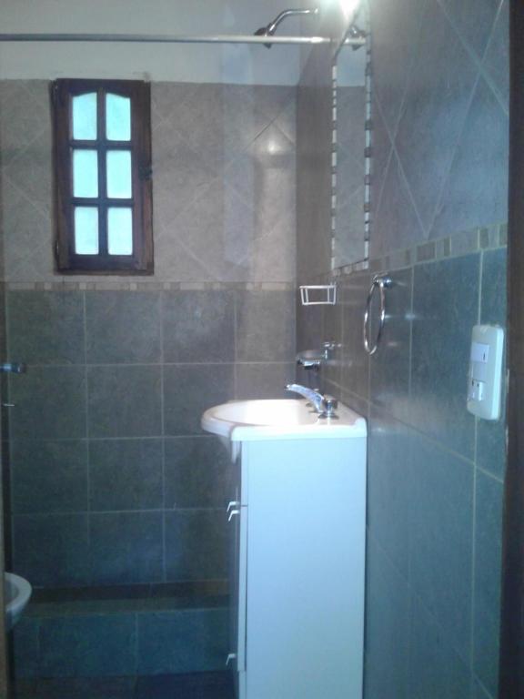 baño con lavabo y ducha con ventana en Cabañas Mar Azul en Balneario Mar Azul